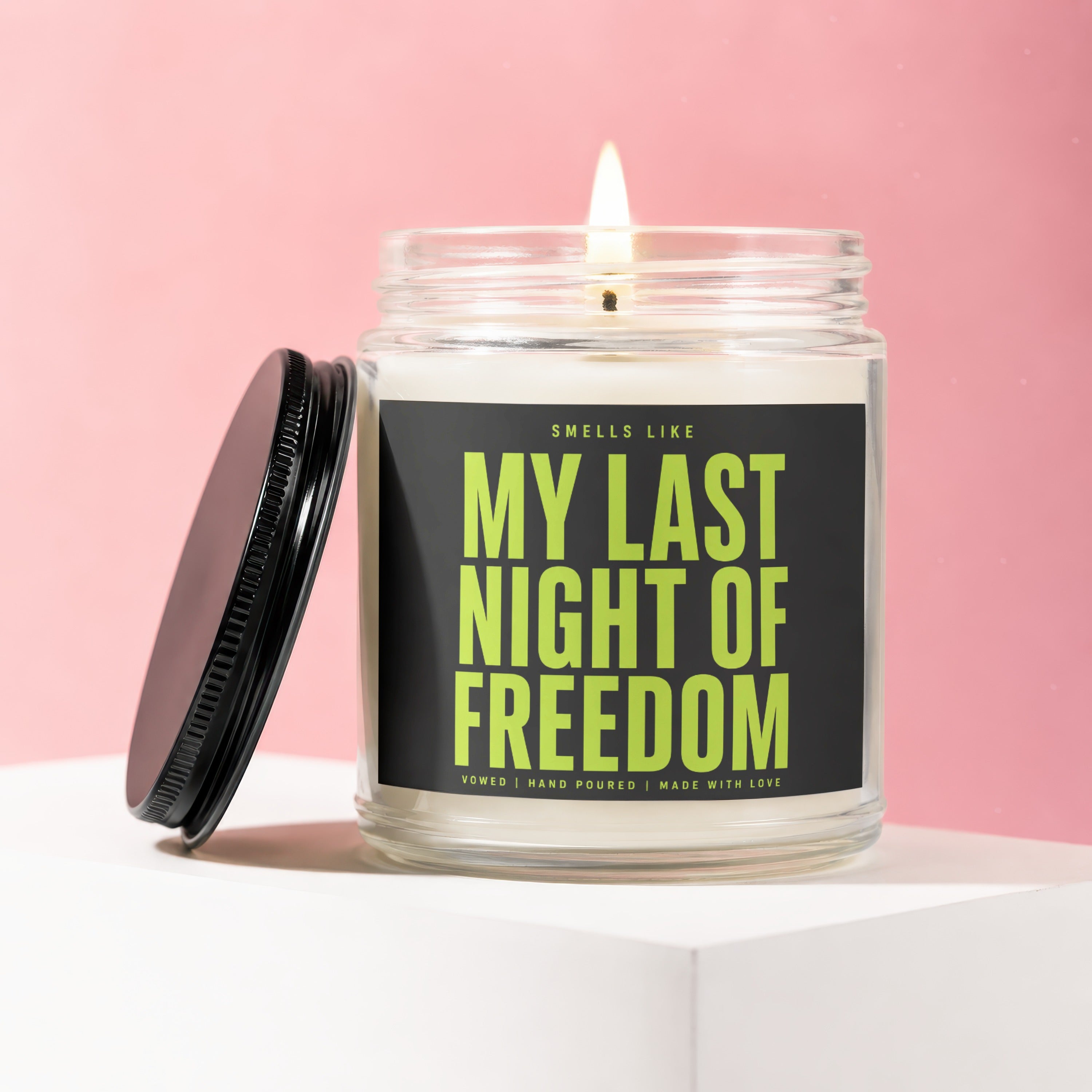 Candle with black lid titled "My Last Night of Freedom" on a pink background.