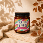Amber jar candle with "BRIDE TRIP!" and "VOWED" text on a colorful label.