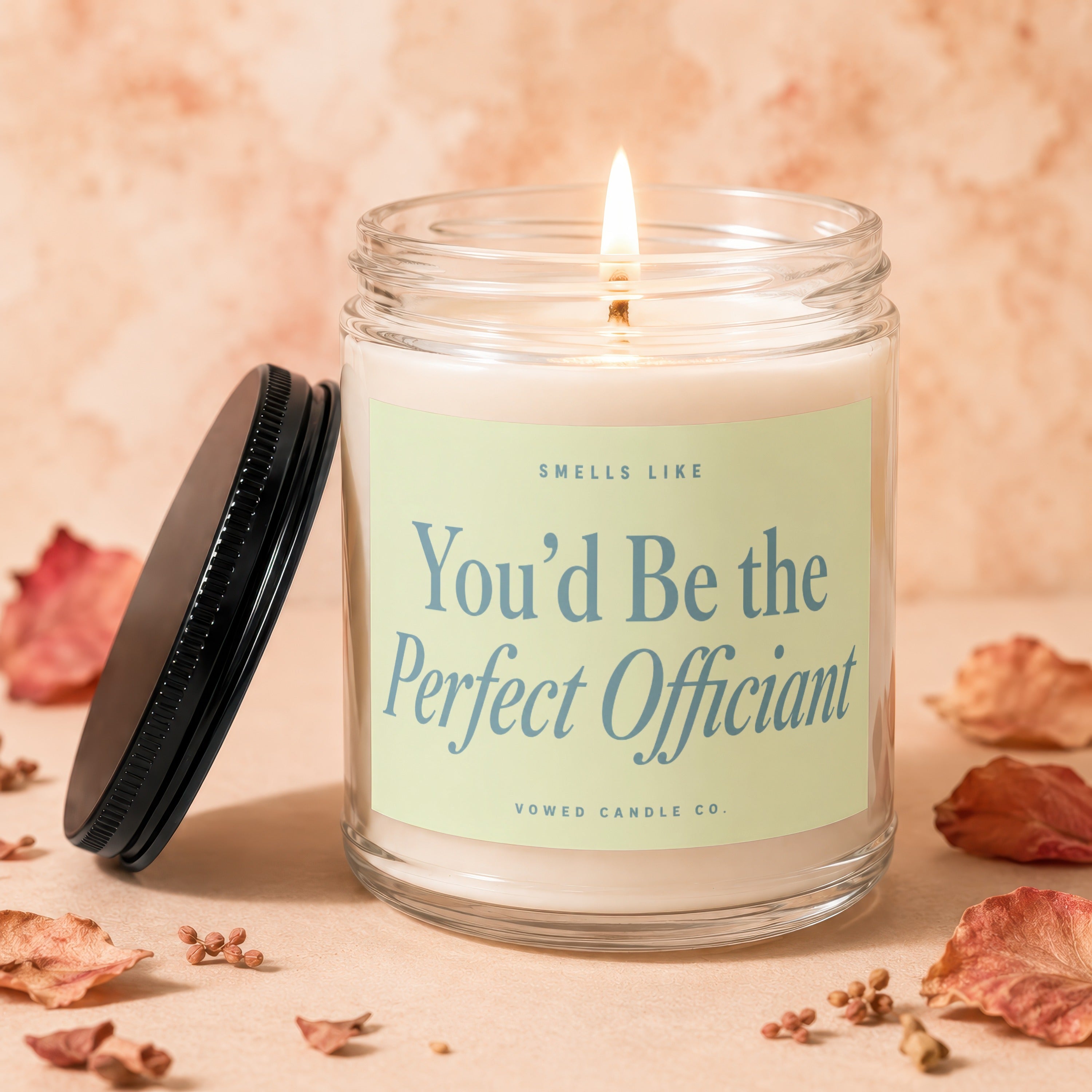 Glass candle with lit wick and "You'd Be the Perfect Officiant" text.