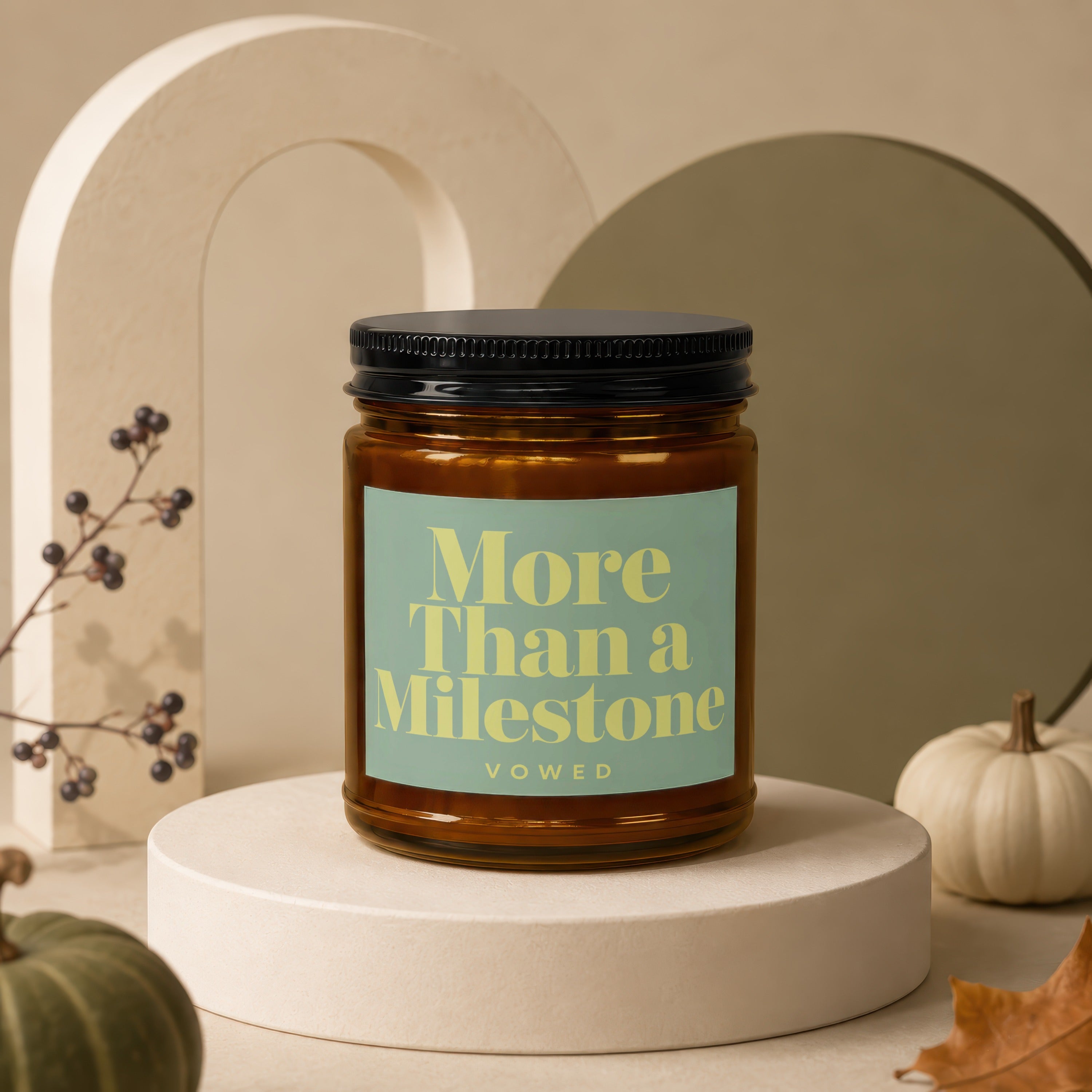 Amber jar candle with black lid, label reads "More Than a Milestone" and "vowed".