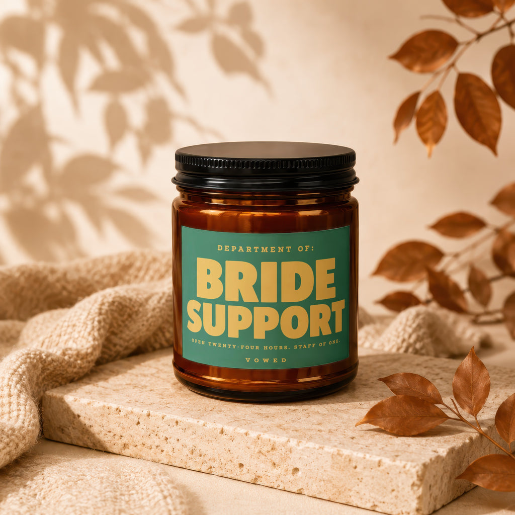 Brown glass candle jar with label reading "BRIDE SUPPORT" and "VOWED".