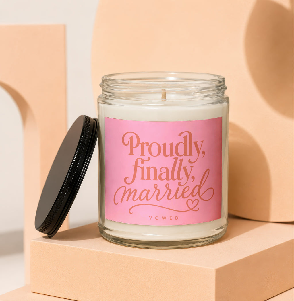 Candle with pink label that reads "Proudly, finally married" and "VOWED".