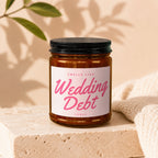 Amber jar candle labeled "Smells Like Wedding Debt" with "Vowed" below.
