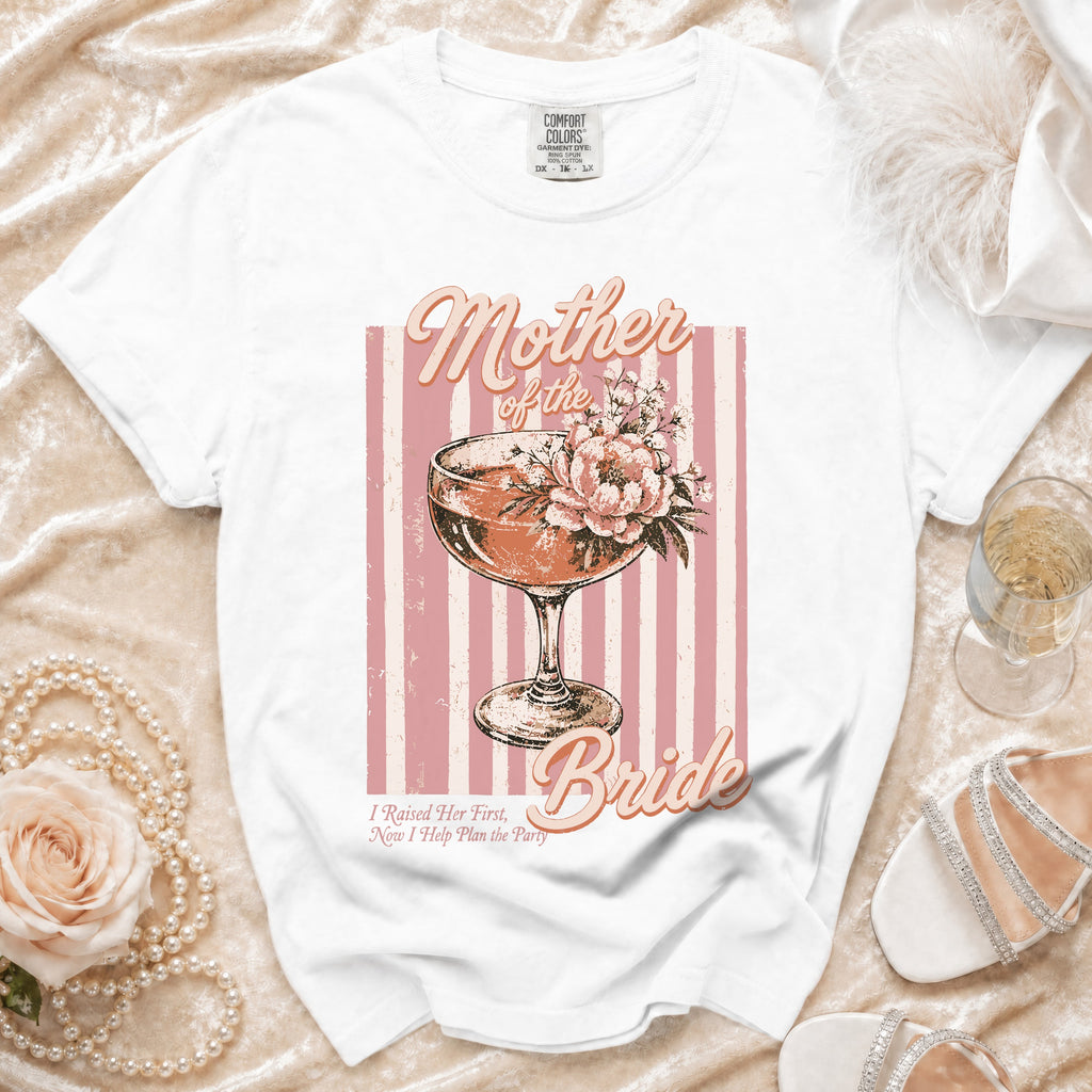 White t-shirt with "Mother of the Bride" text and floral cocktail graphic.