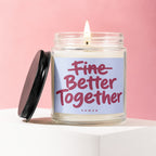 Glass candle with lit flame and lid, reads "Better Together" VOWED.