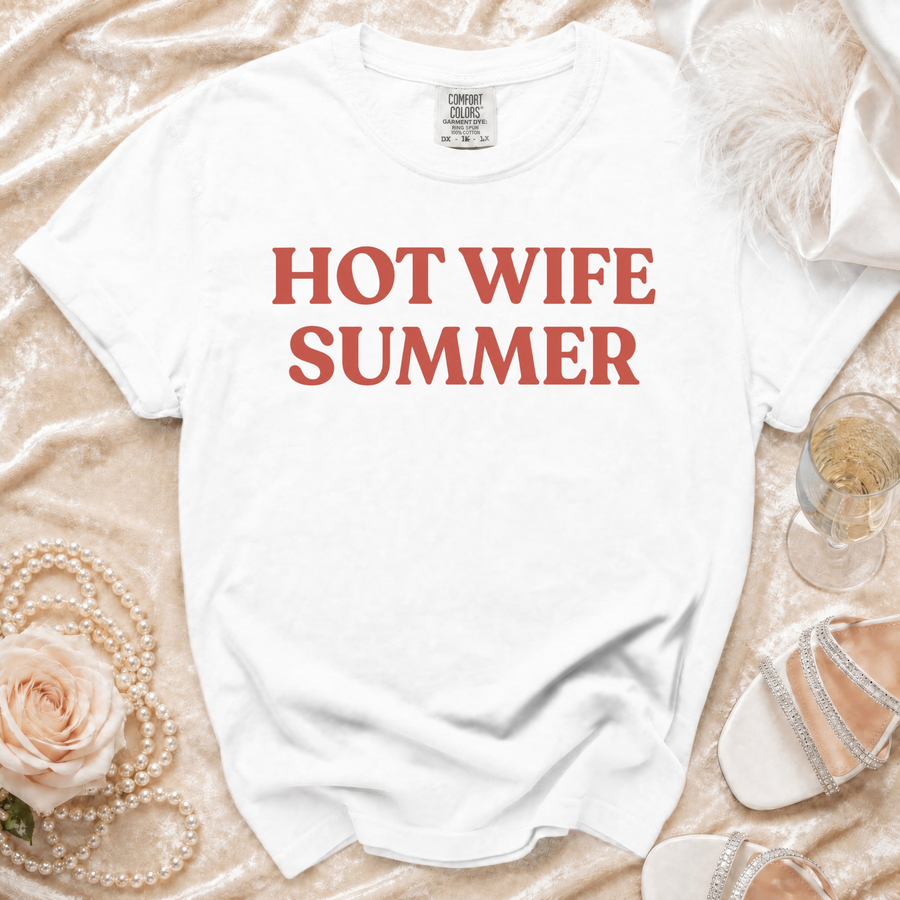 White t-shirt with red text "HOT WIFE SUMMER" styled with pearls and sandals.