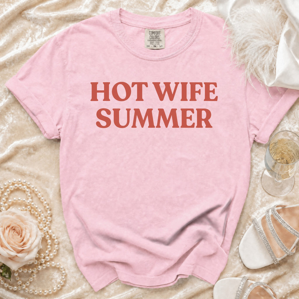 Pink t-shirt with "HOT WIFE SUMMER" text, featuring pearl necklace, rose, champagne, and sandals.