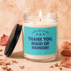Candle with blue label reading "Thank You, Maid of Honor!" and a lit wick.