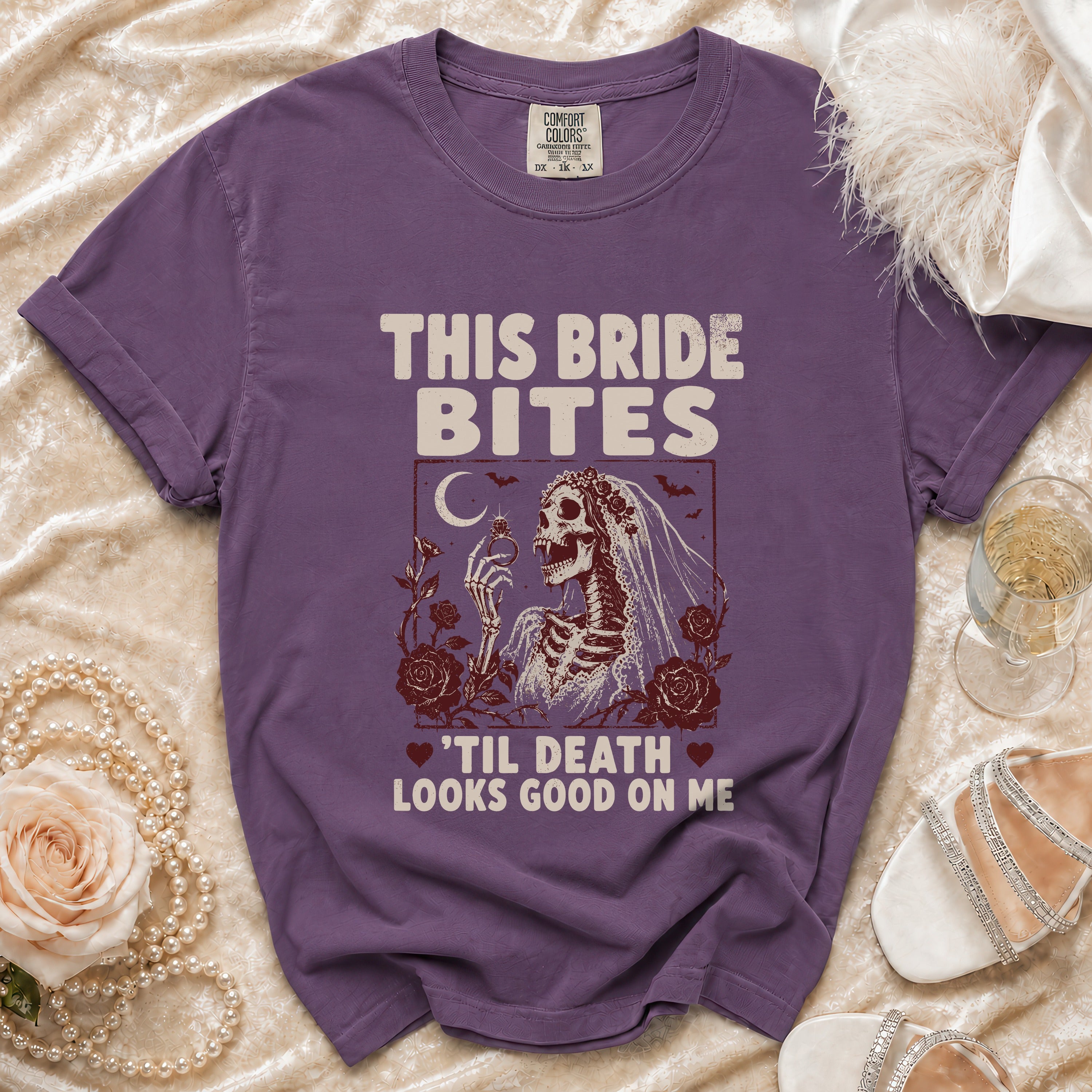 Purple t-shirt with "This Bride Bites 'Til Death Looks Good On Me" text and skeleton bride graphic.