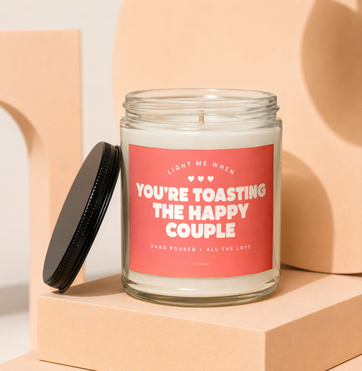 Candle with text "Light me when you're toasting the happy couple" and "Vowed".