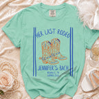 Mint t-shirt with "Her Last Rodeo Jennifer's Bach Nashville, TN Summer 2026" and cowboy boots.