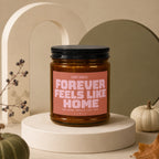 Candle with text "Forever Feels Like Home" surrounded by autumnal decor.