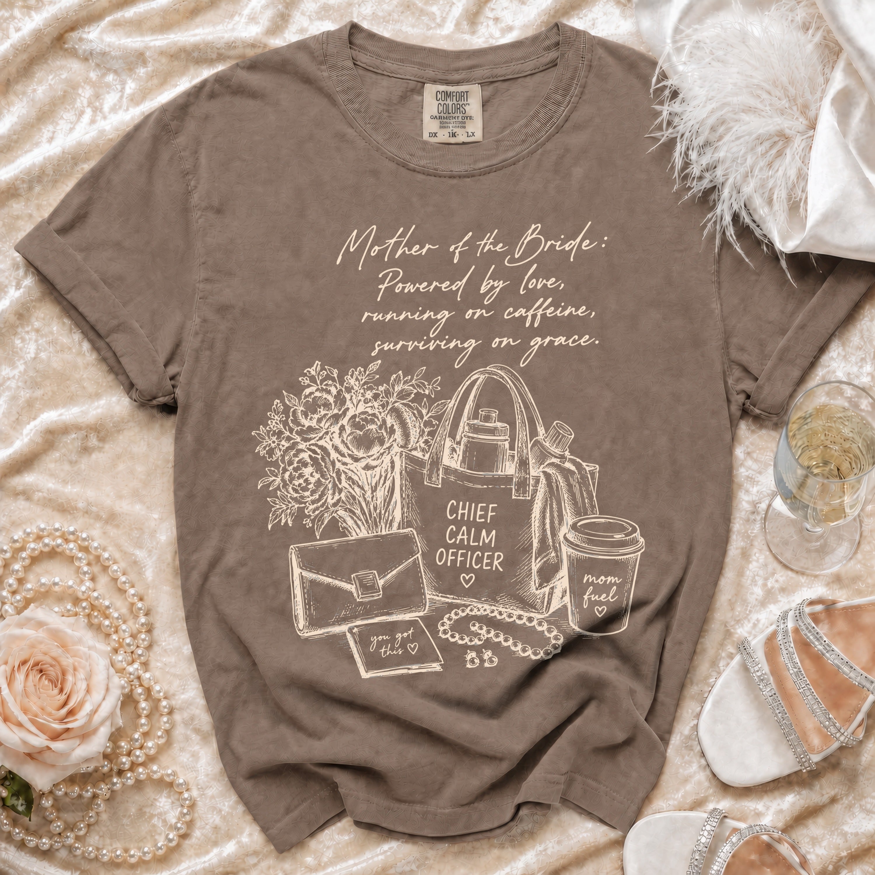Brown t-shirt with "Mother of the Bride: Powered by love, running on caffeine, surviving on grace" text and graphics.