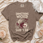 Brown t-shirt with "Something Wicked Said I Do" text, skeleton hand, skull, and roses graphic.