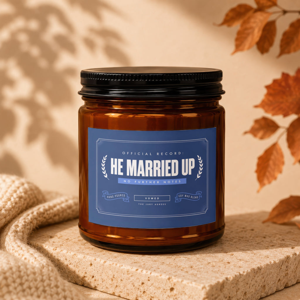 Amber candle with blue label reading "HE MARRIED UP" and "VOWED".