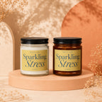 Two "Sparkling Stress" candles, one clear and one amber, on peach pedestals.