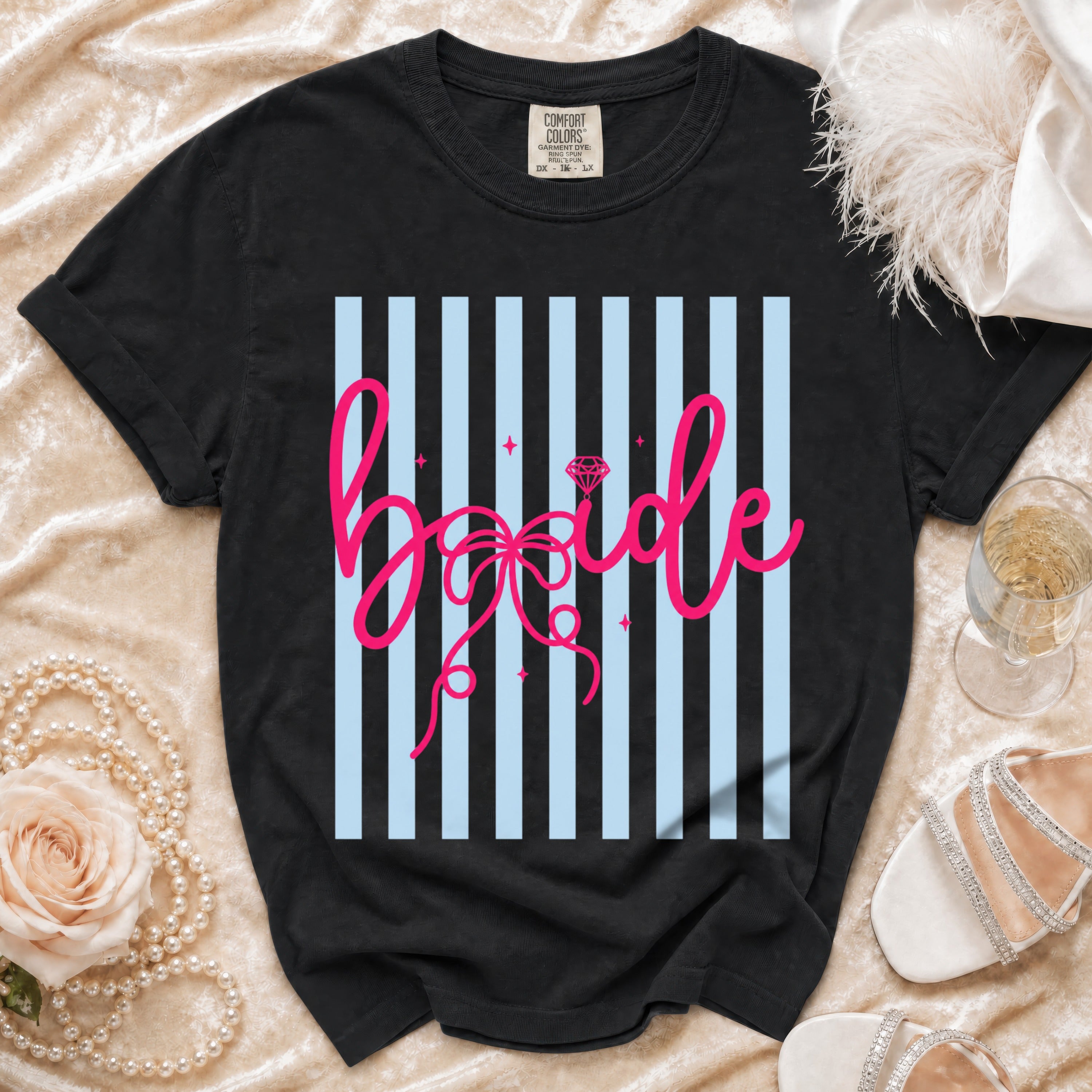 Black t-shirt with pink "bride" text and diamond graphic on striped background.