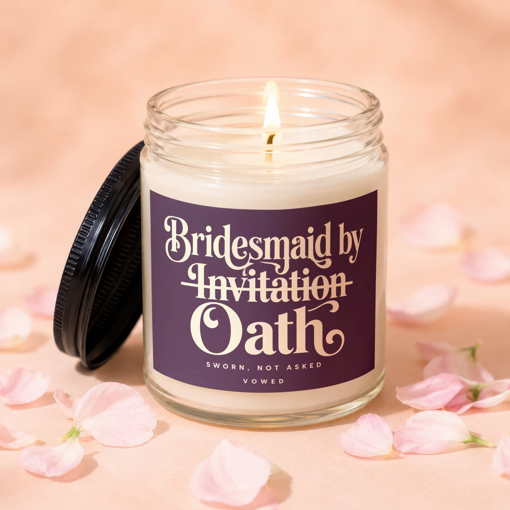 Candle with "Bridesmaid by Invitation Oath" text and petals on a peach background.
