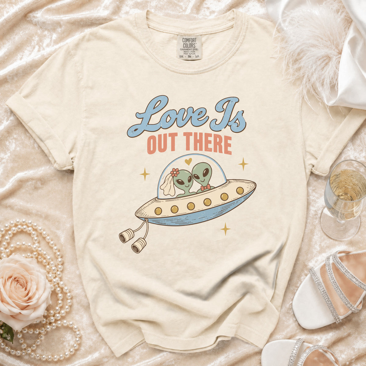 Cream t-shirt with aliens in a UFO, text "Love Is Out There"