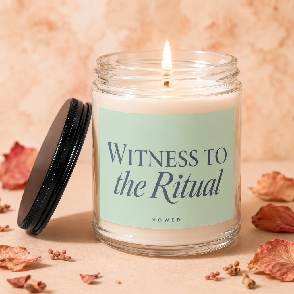 Glass jar candle with lit wick, light green label reading "WITNESS TO the Ritual VOWED".