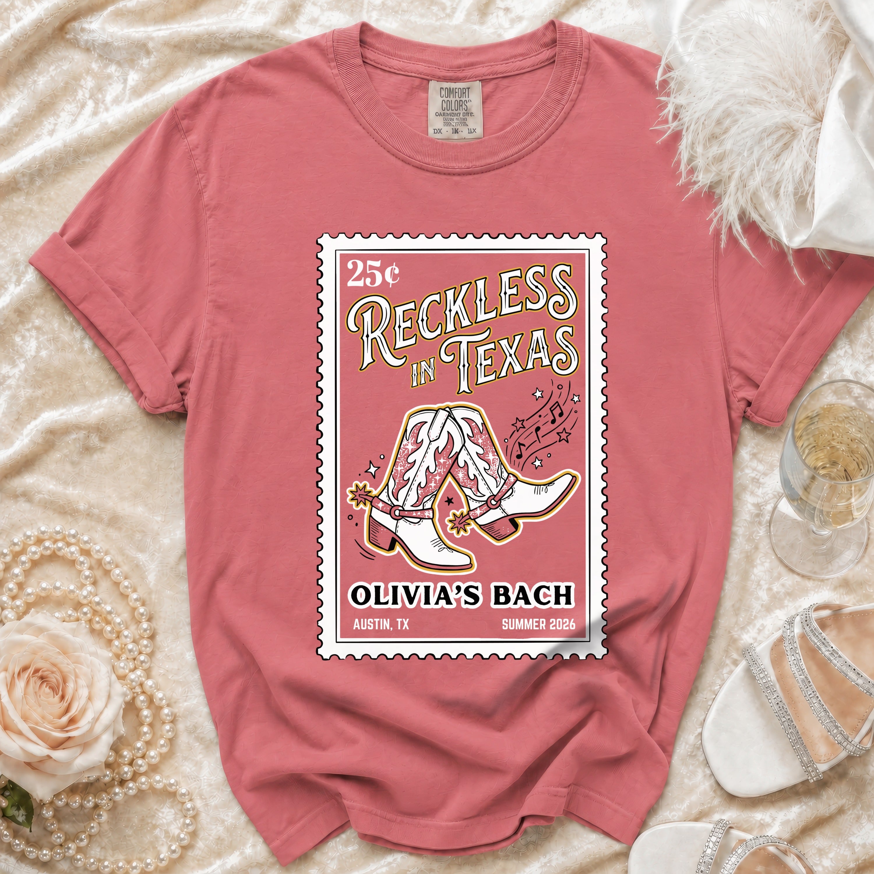 T-shirt with pink stamp design featuring cowboy boots, "Reckless in Texas", and "Olivia's Bach".