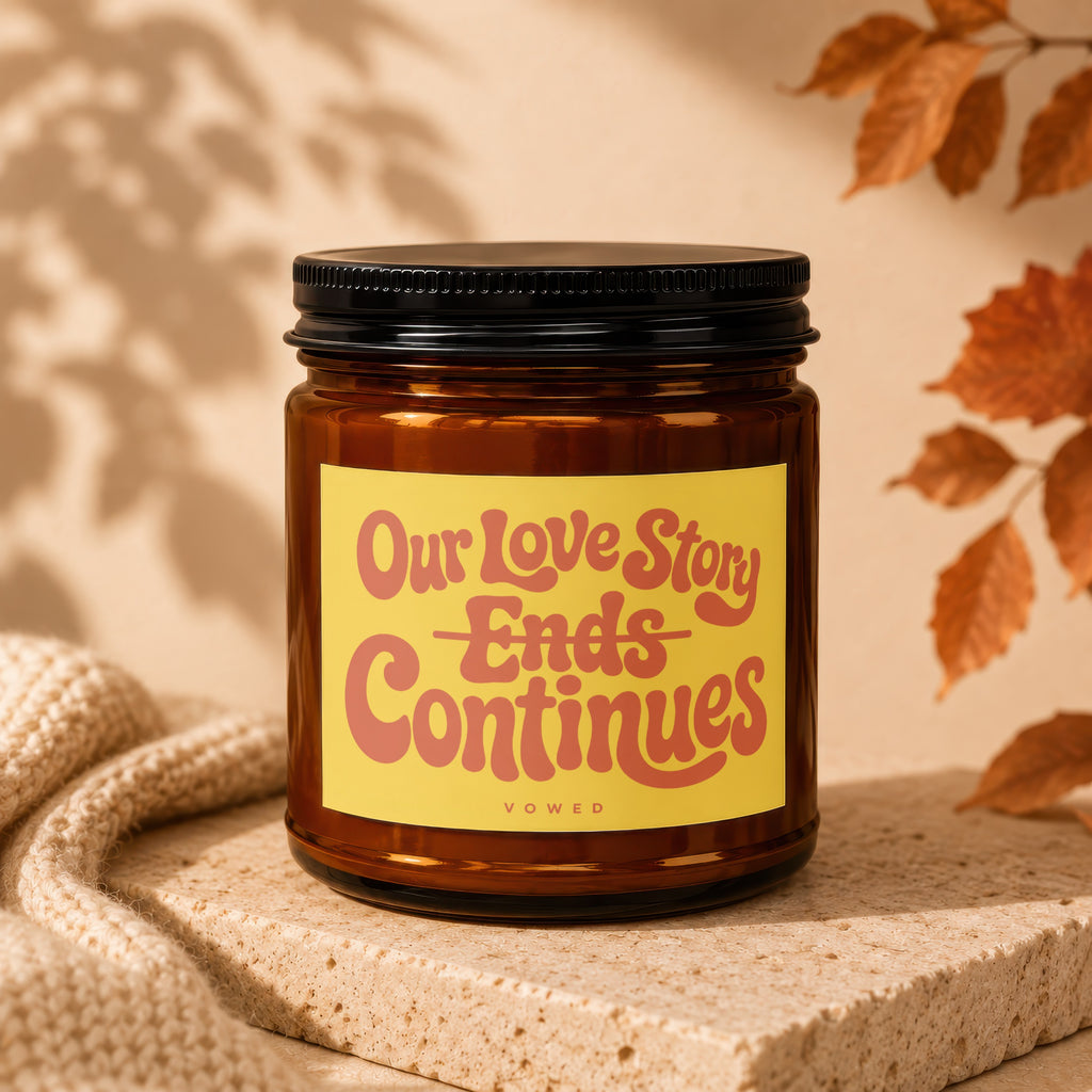 Brown glass candle with yellow label reading "Our Love Story Ends Continues"