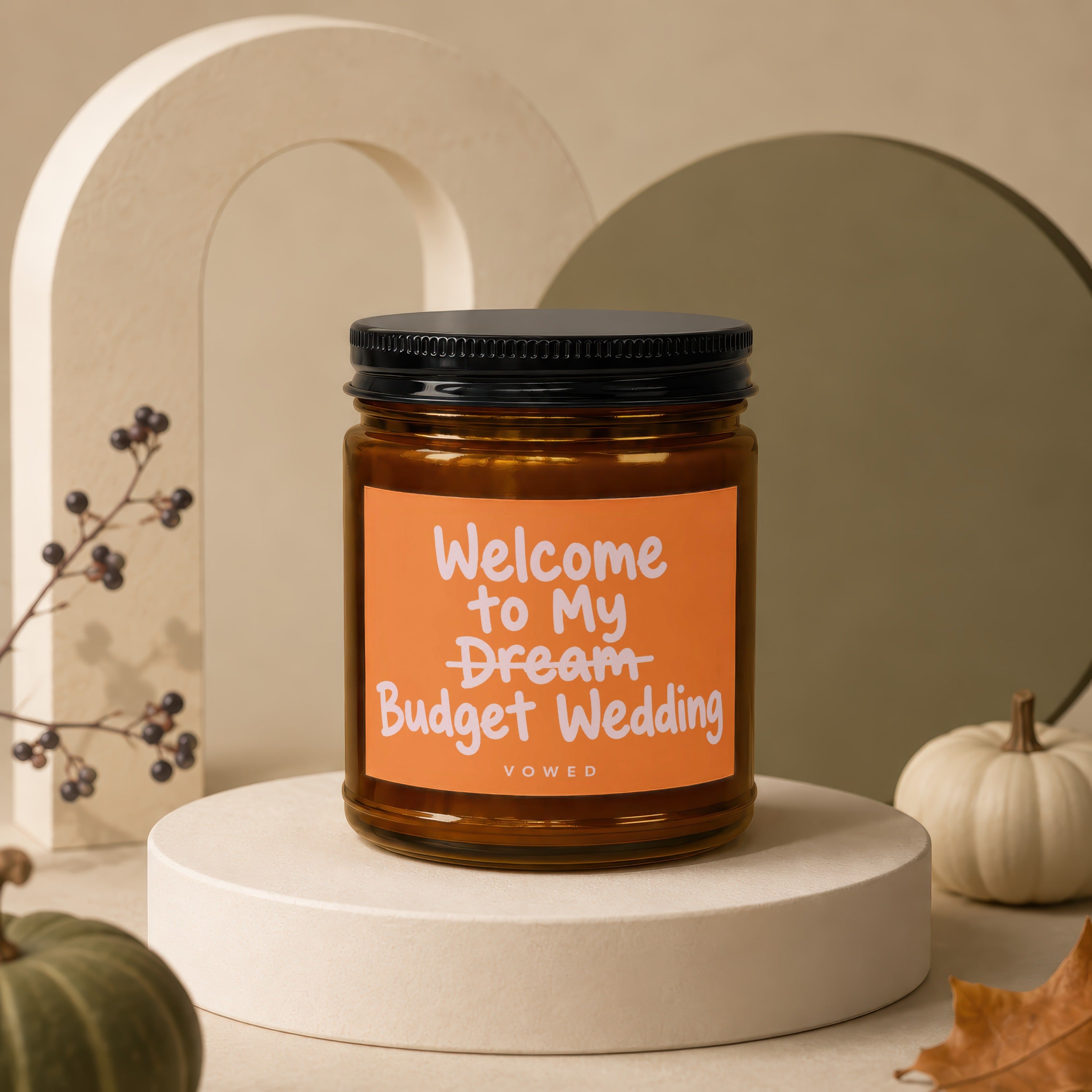 Candle with orange label reading "Welcome to My Dream Budget Wedding."
