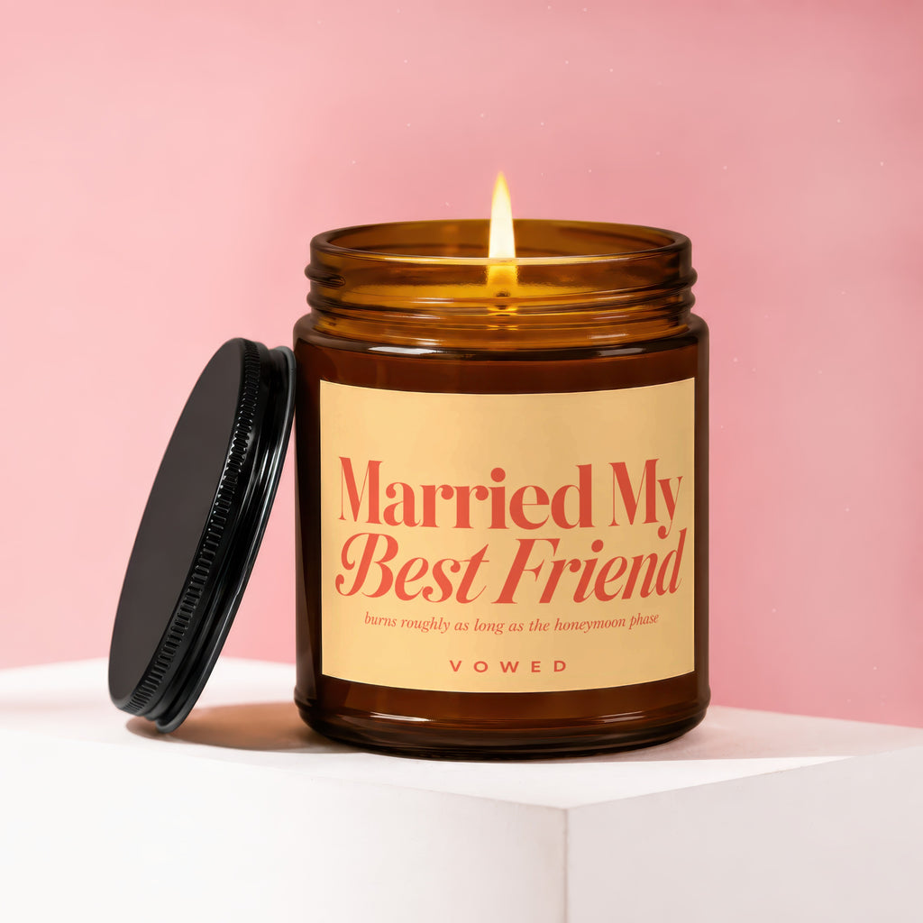 Amber jar candle with lit flame, reads "Married My Best Friend" and "VOWED."