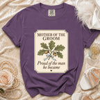 Purple t-shirt with "Mother of the Groom, Proud of the man he became" text and oak illustration.