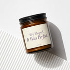 Brown jar candle with black lid and cream label reading "We Eloped. It Was Perfect."