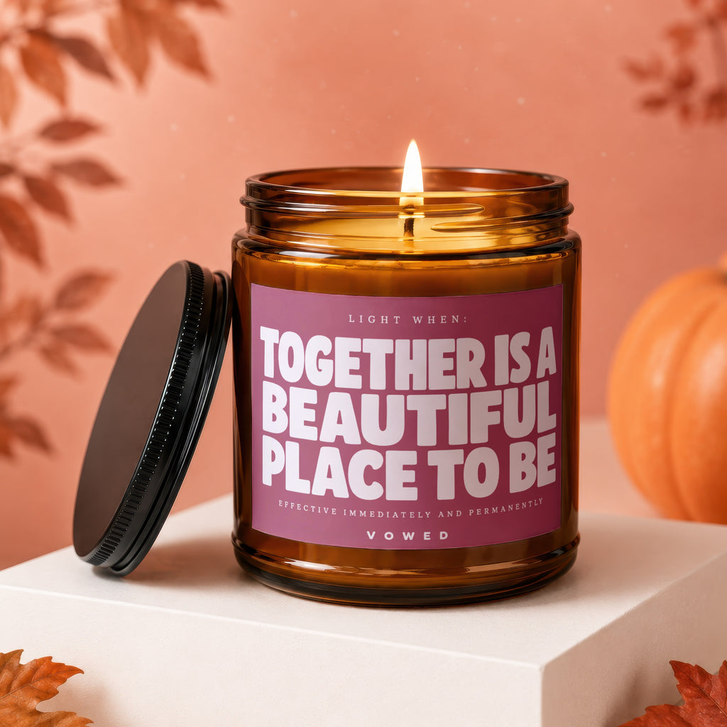 Amber jar candle labeled "TOGETHER IS A BEAUTIFUL PLACE TO BE" with lid off.