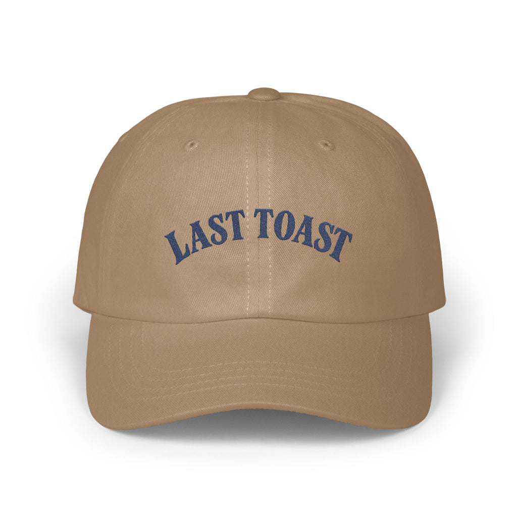Tan baseball cap with "LAST TOAST" embroidered in blue on the front.