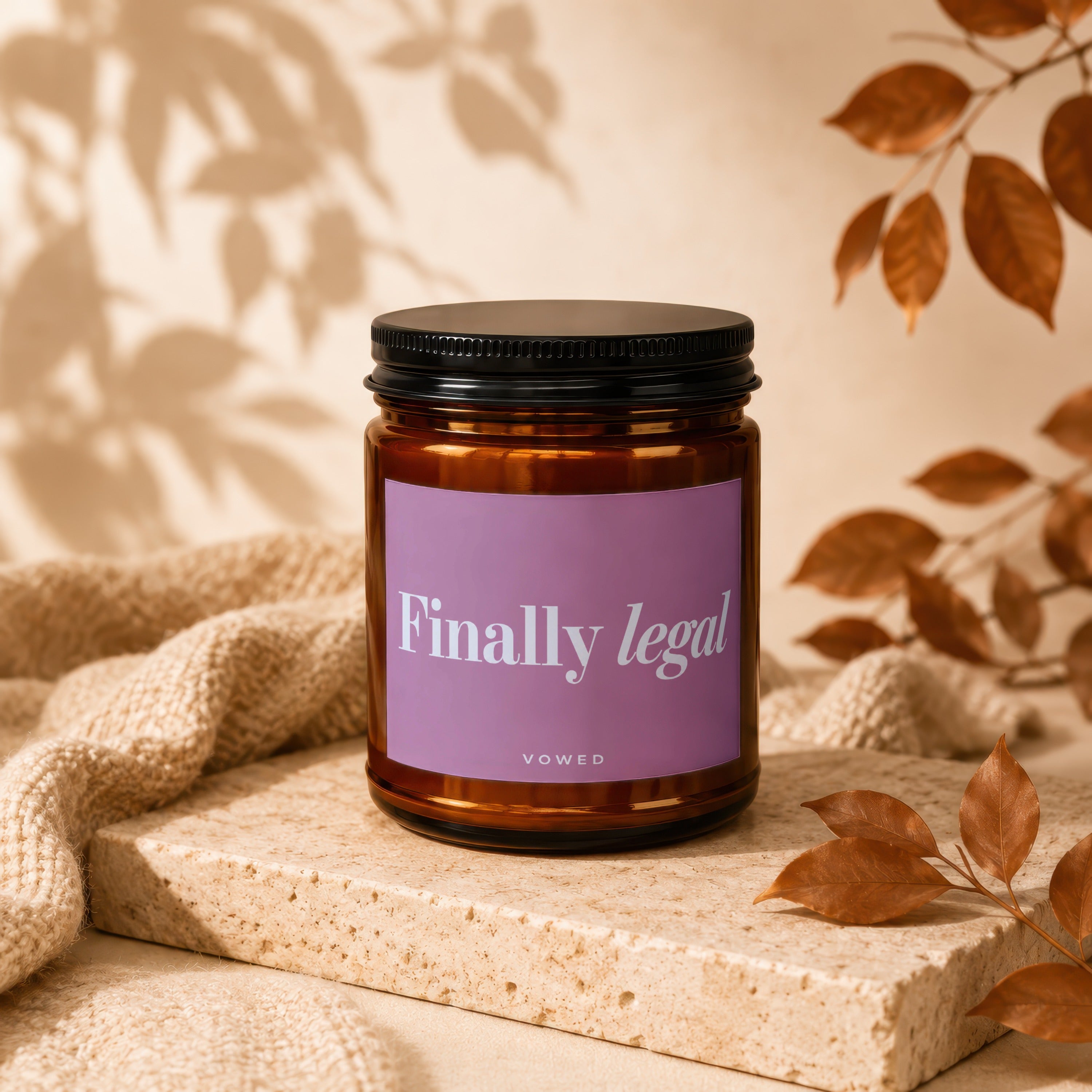 Amber jar candle with purple label reading "Finally legal" by VOWED.