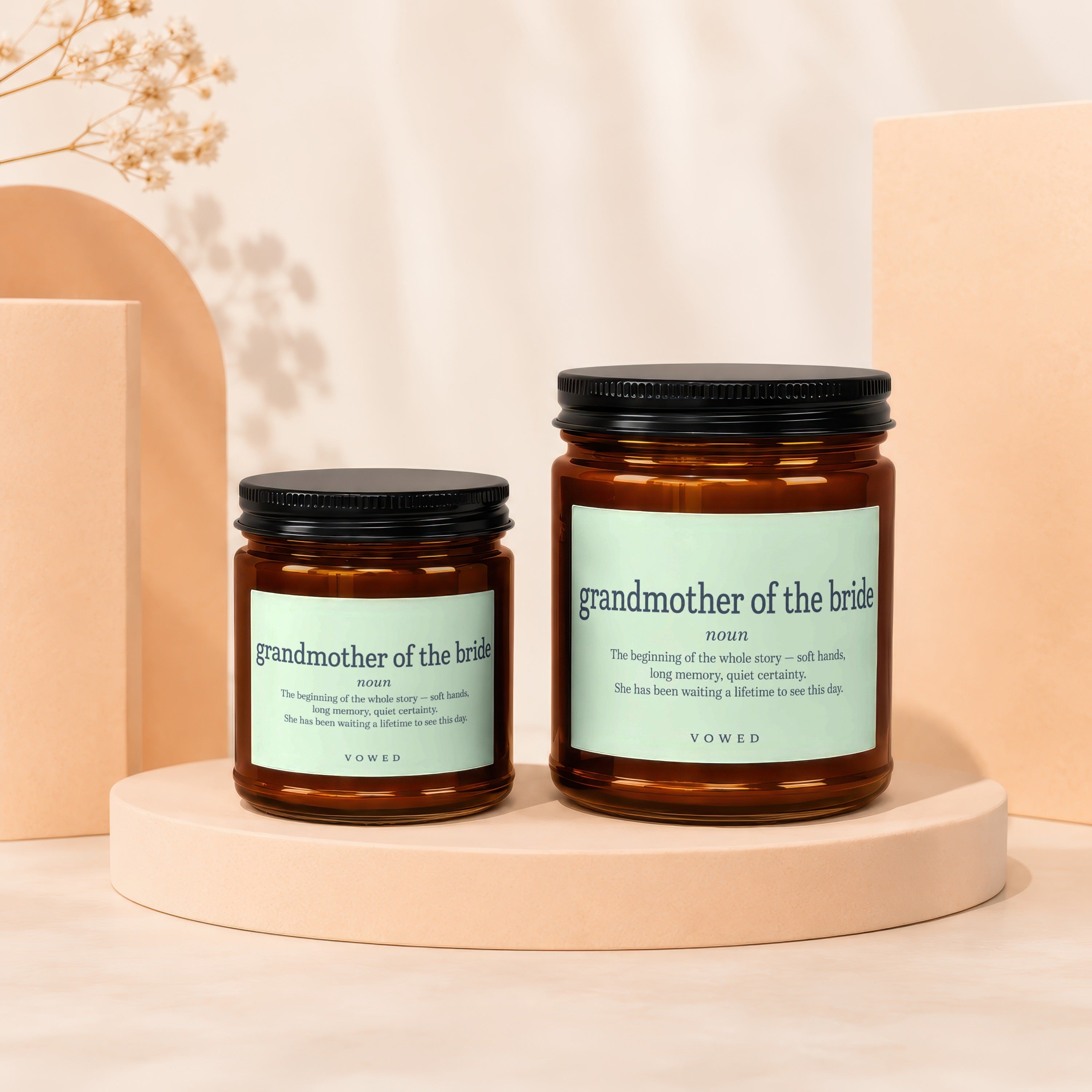 Two amber glass candles labeled "grandmother of the bride" with black lids.