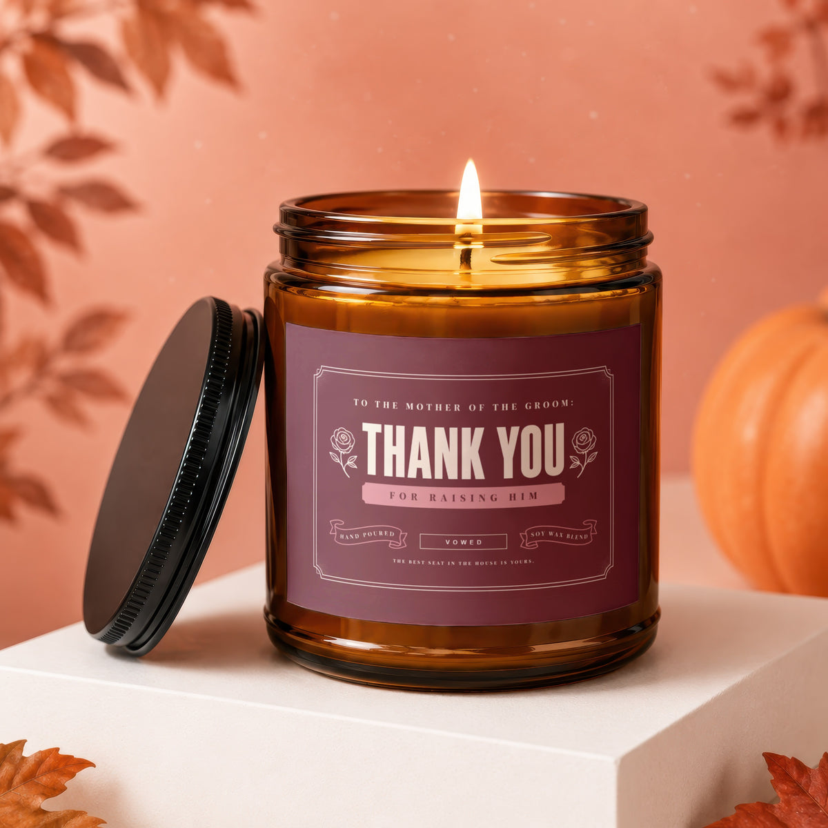 Amber jar candle with a dark label reading "Thank You For Raising Him" with decorative roses.
