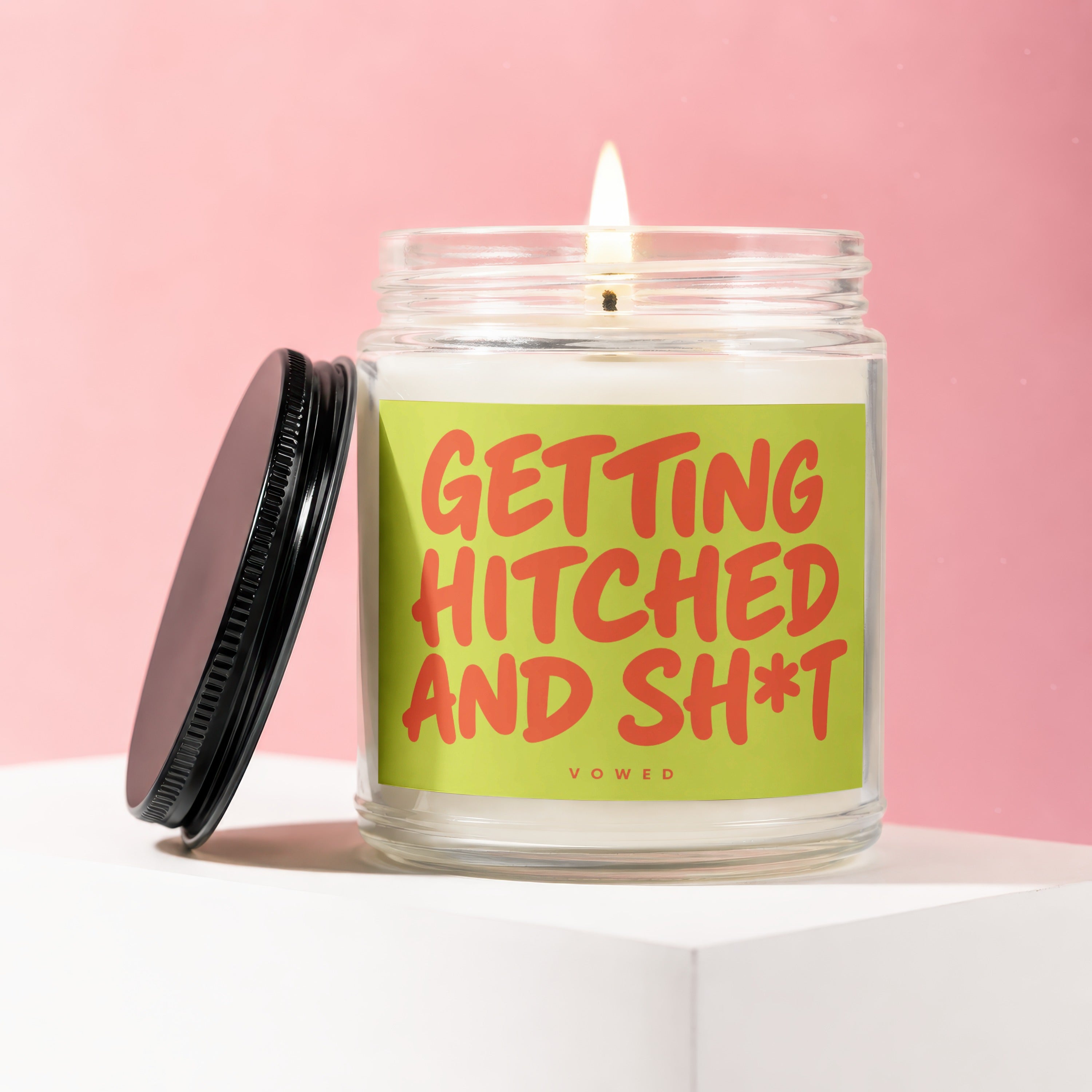 Candle with orange text "GETTING HITCHED AND SH*T" on a lime green label.