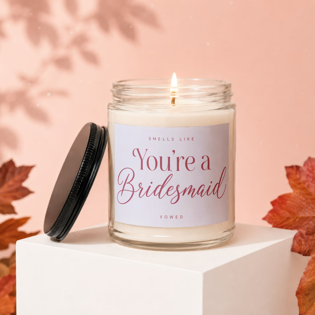 Jar candle labeled "Smells Like You're a Bridesmaid" with lid off.