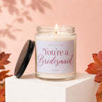 Jar candle labeled "Smells Like You're a Bridesmaid" with lid off.