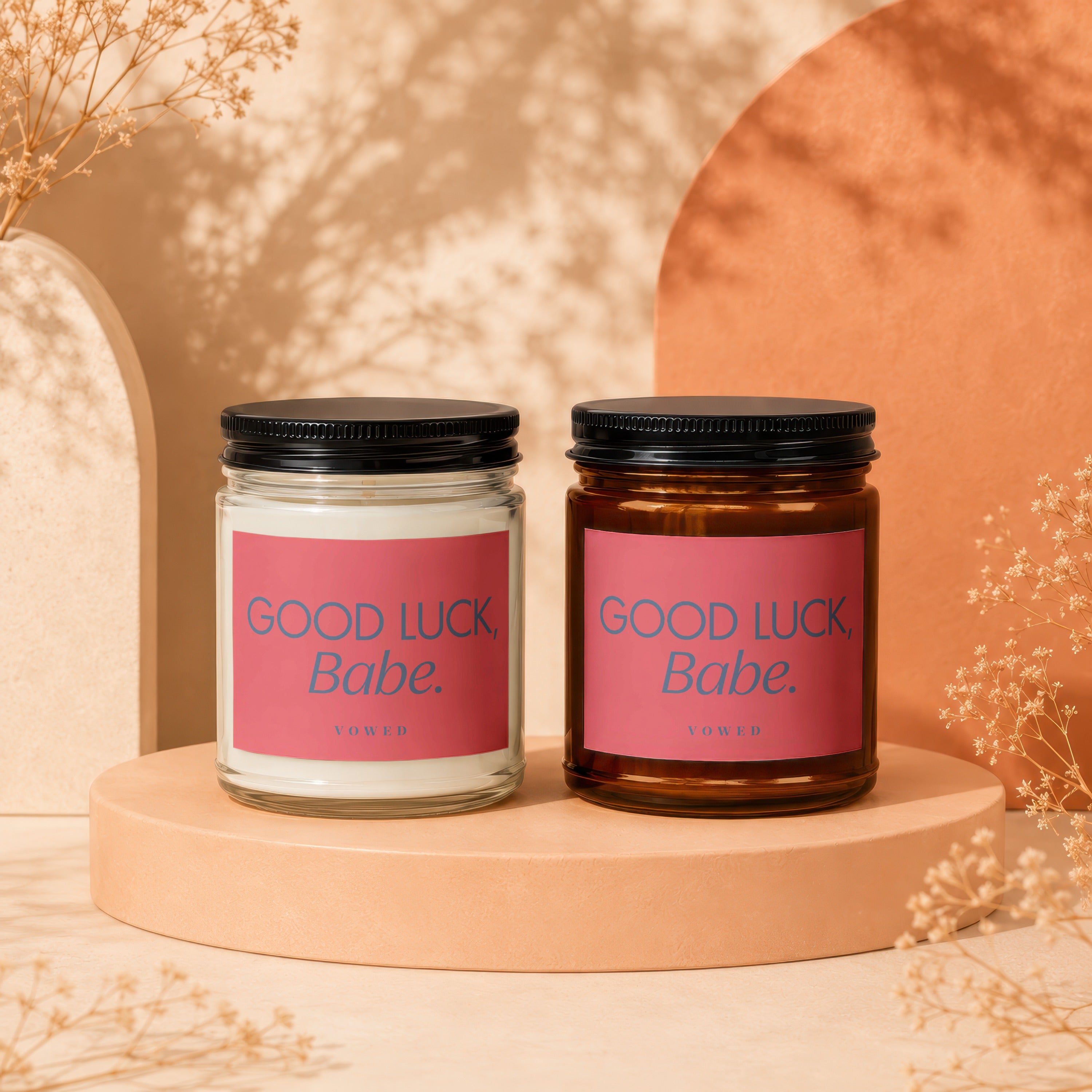 Two VOWED candles with pink labels reading "GOOD LUCK, Babe."
