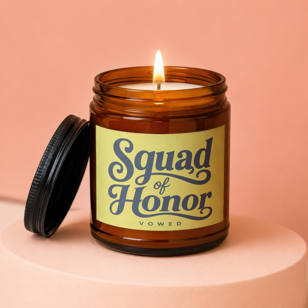 Amber jar candle with lit flame and "Squad of Honor", "VOWED" text on label.