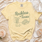 Yellow t-shirt with "Reckless in Texas Olivia's Bach Austin, TX Summer 2026" design.
