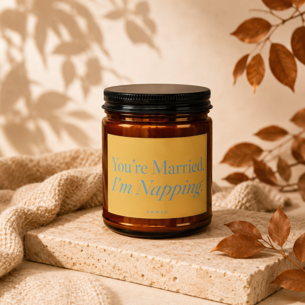 Amber jar candle with "You're Married. I'm Napping." text on yellow label.