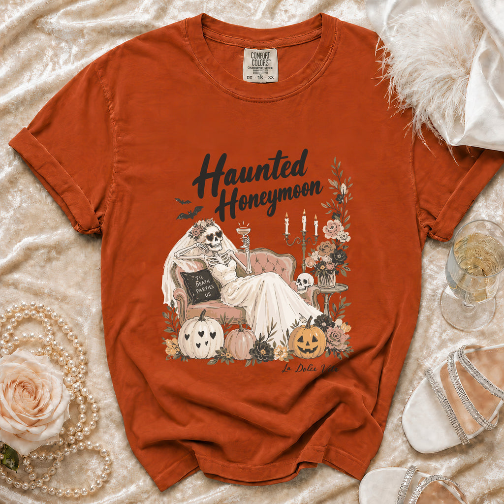 Orange Comfort Colors t-shirt with "Haunted Honeymoon" graphic of skeleton bride and pumpkins.