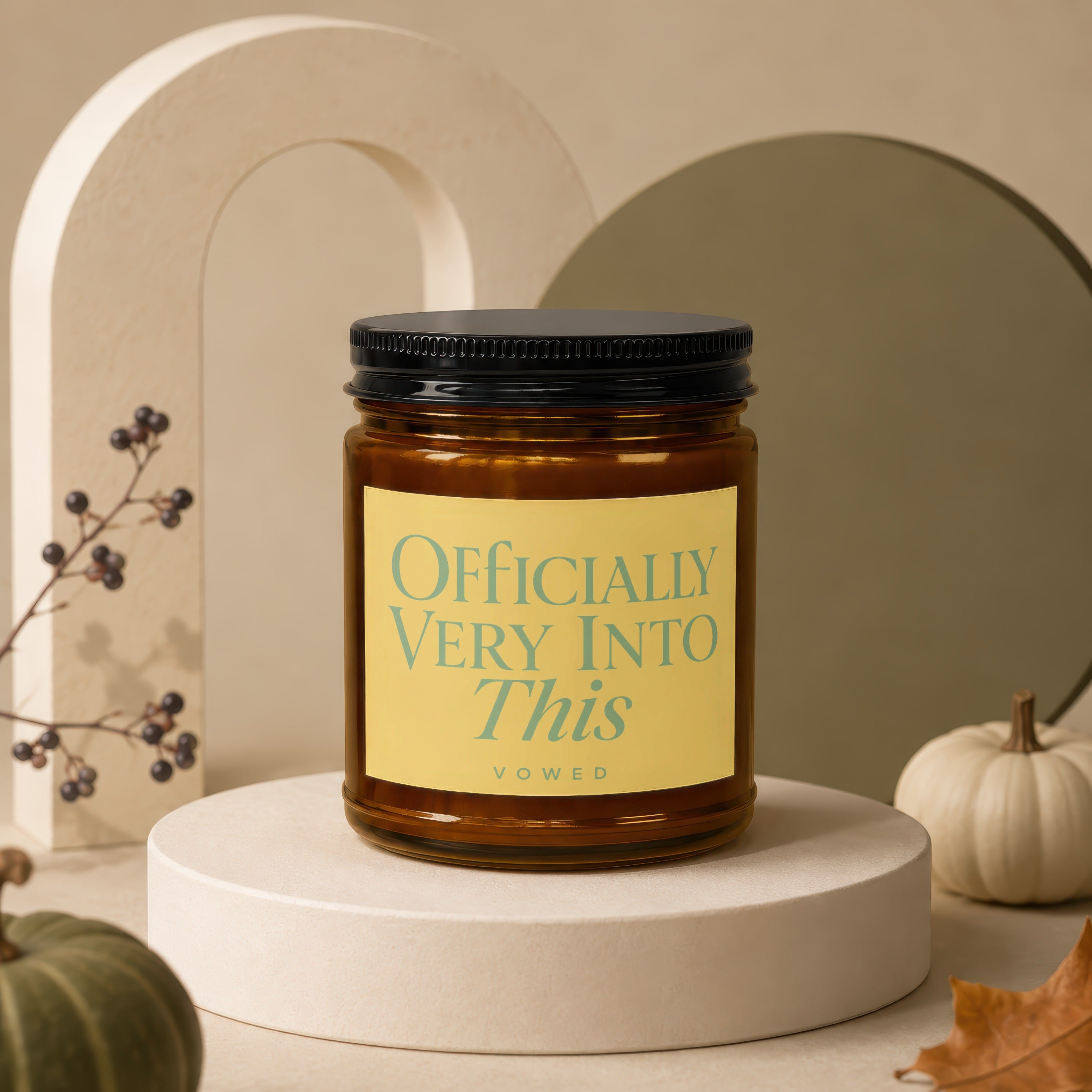Amber glass candle with black lid, yellow label reading "Officially Very Into This".