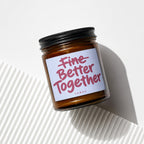 Candle with label reading "Fine Better Together" on white background.
