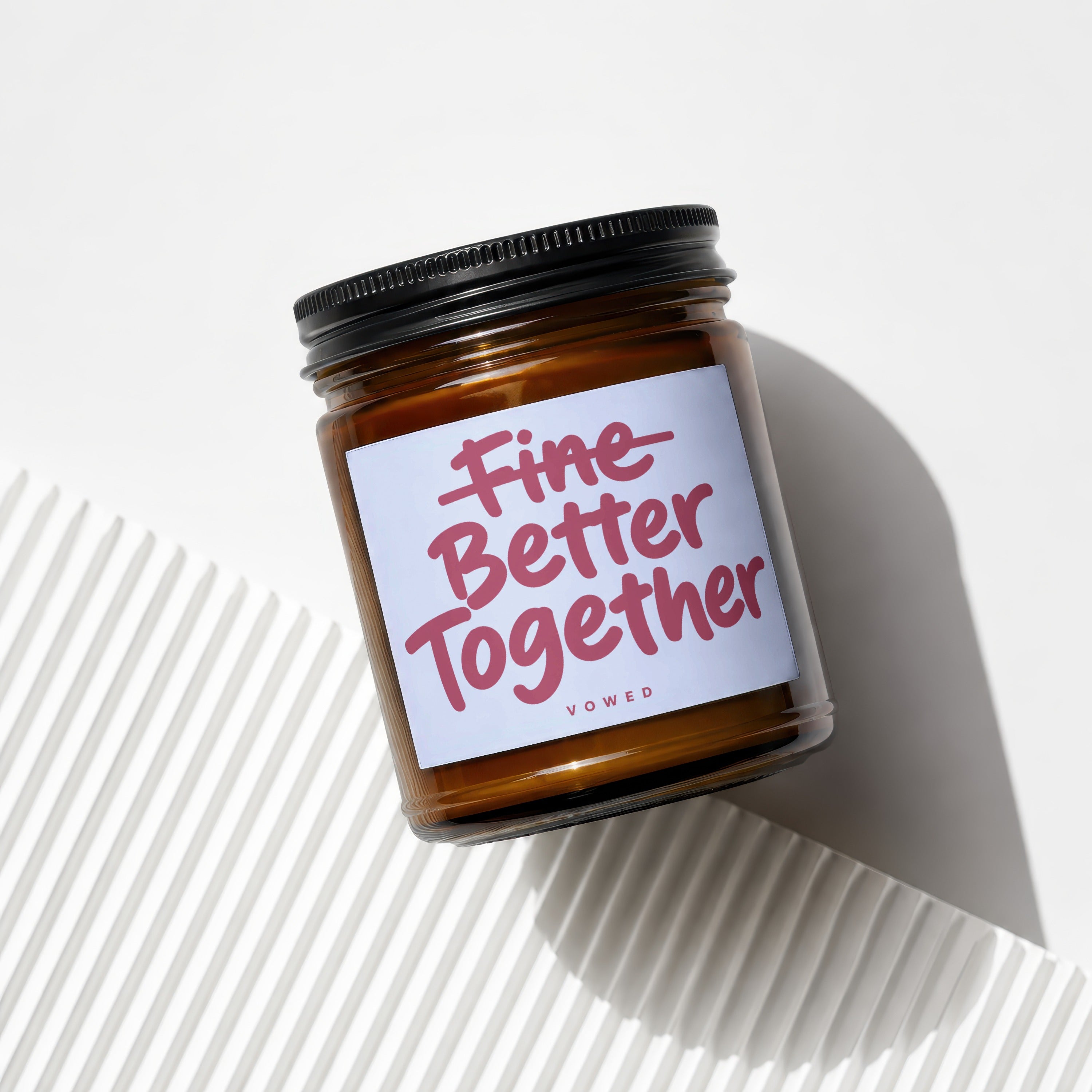 Candle with label reading "Fine Better Together" on white background.