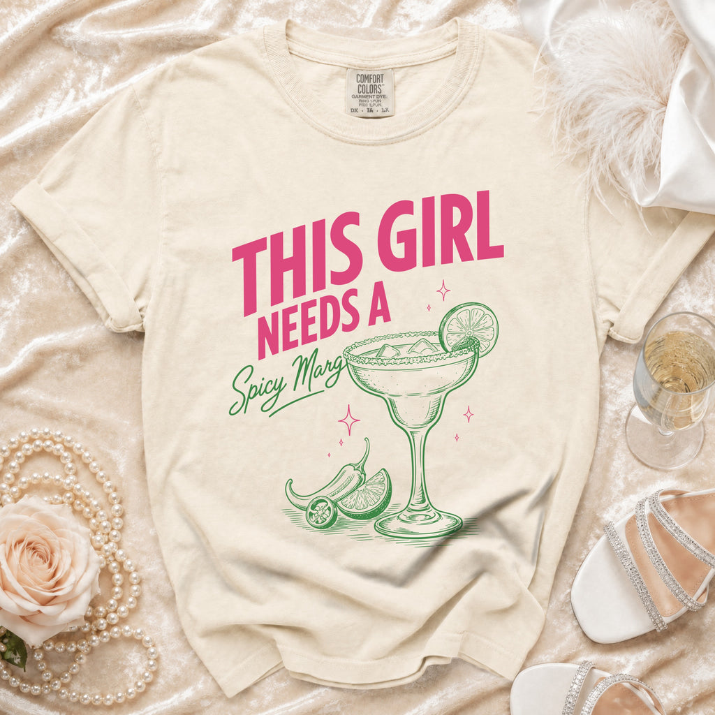 Cream t-shirt with pink text "THIS GIRL NEEDS A Spicy Margi".