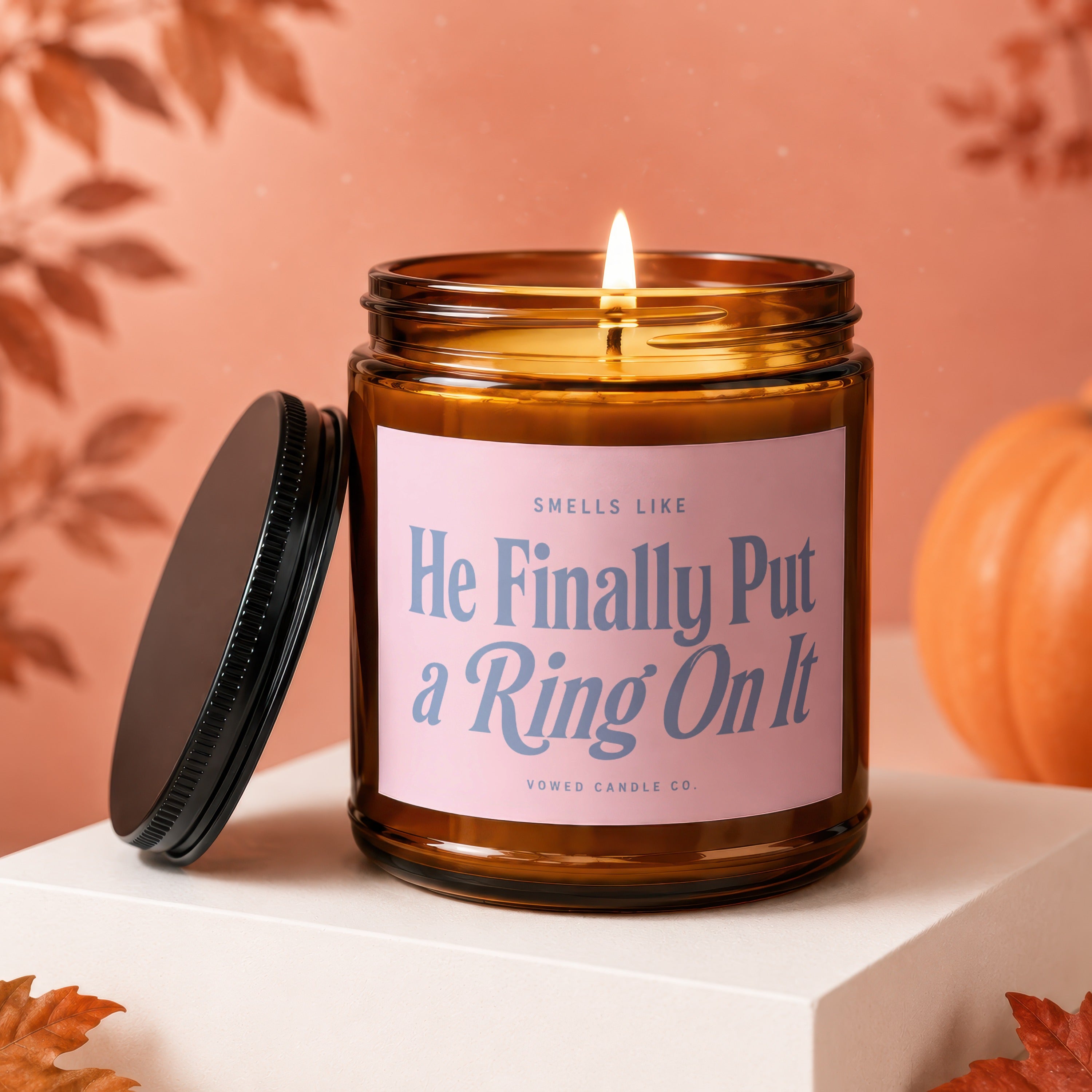 Amber candle with pink label that reads "He Finally Put a Ring On It".