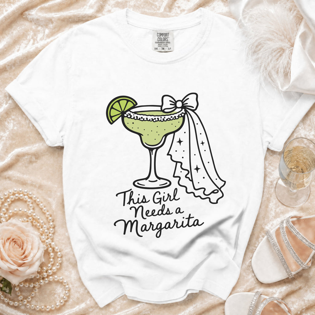 White t-shirt with a graphic of a margarita and the text "This Girl Needs a Margarita".