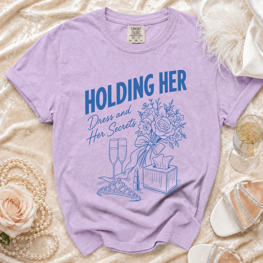 Purple t-shirt with blue graphic text "HOLDING HER Dress and Her Secrets" and illustrations.